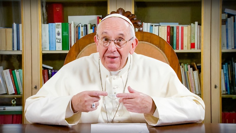 Pope Francis speaking at a desk