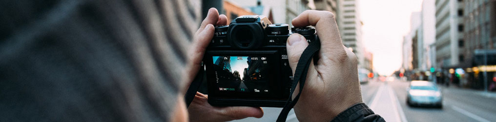 Person holding a camera up to take a picture of a building.
