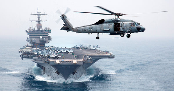 photo of the USS Enterprise with a helicopter flying overhead