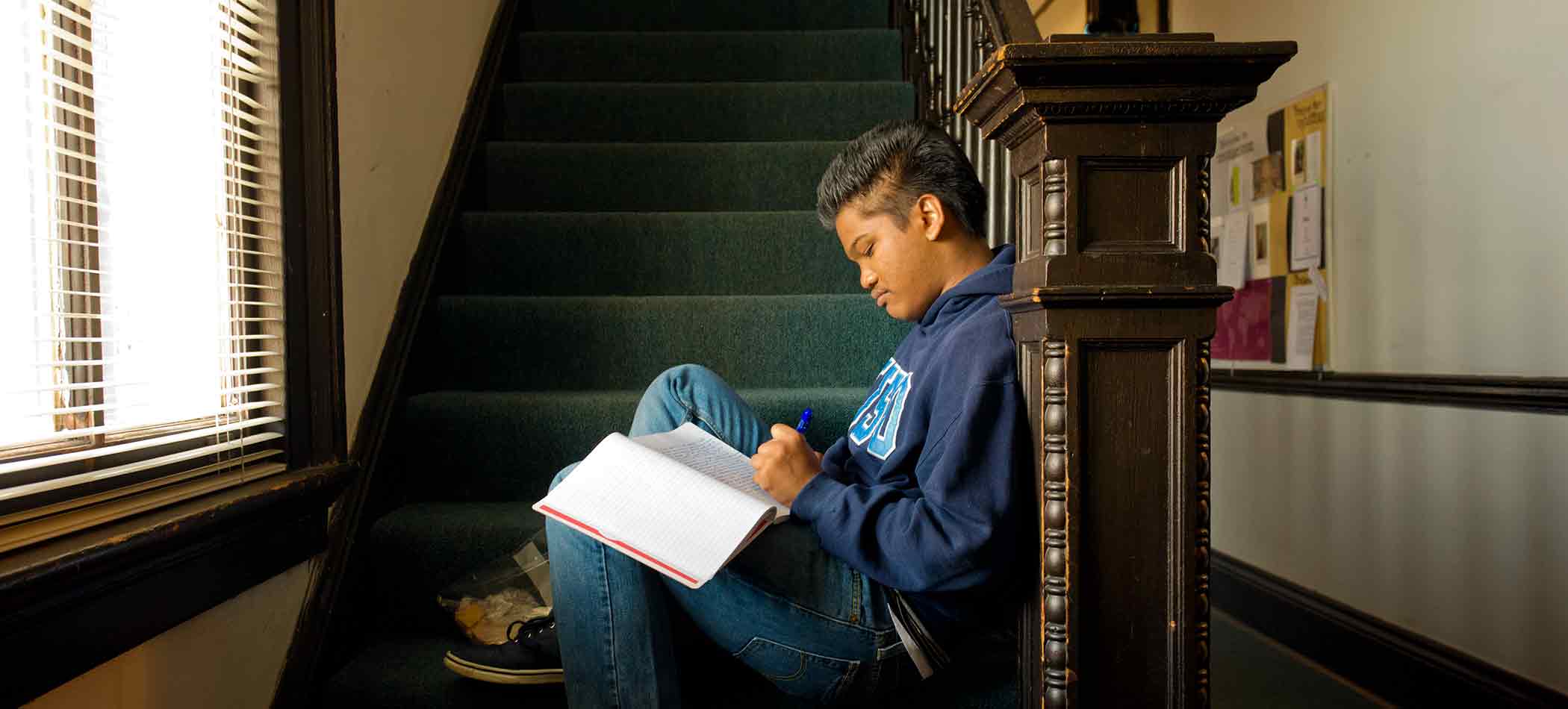 A USD student studies and writes in his notebook