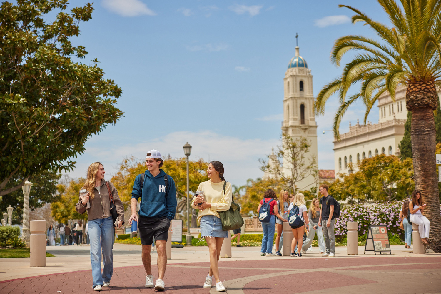 3 students walking and laughing together on campus