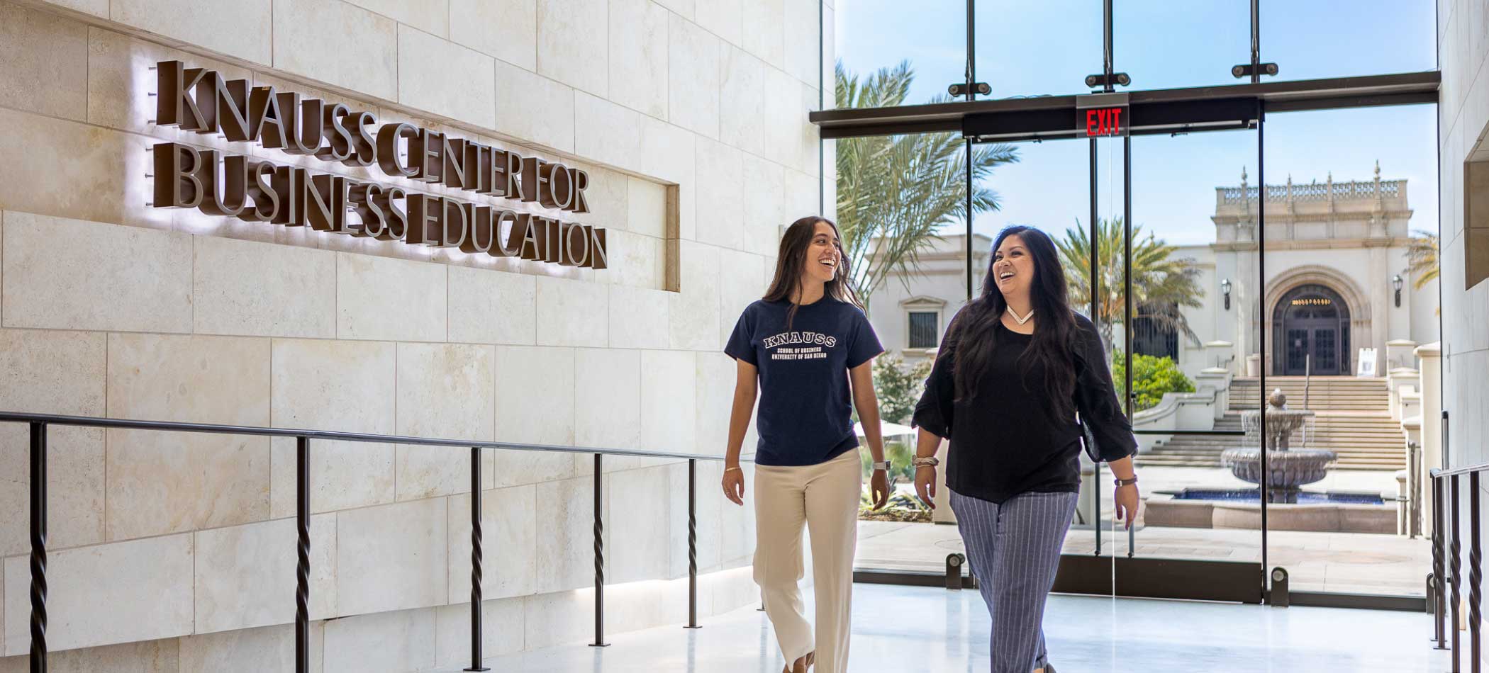 Students talking in front of the Knauss School of Business on the USD campus