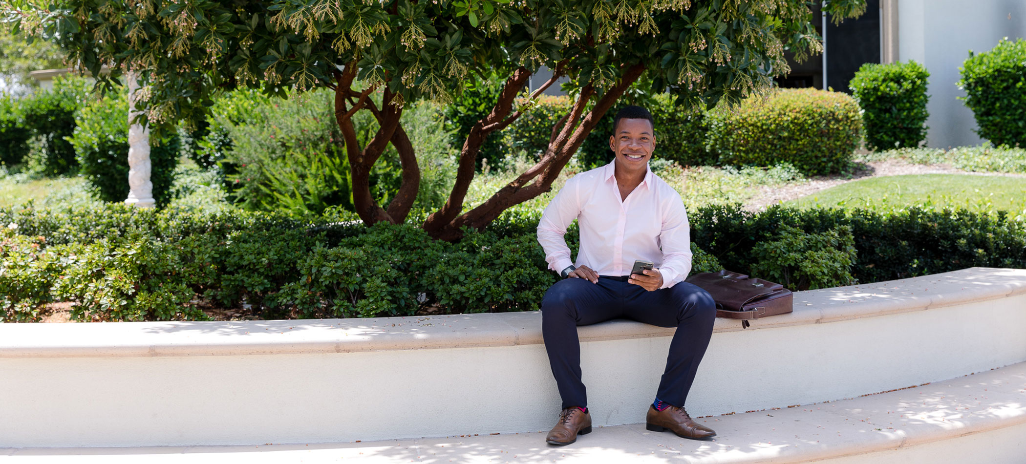 A student sits outside on campus