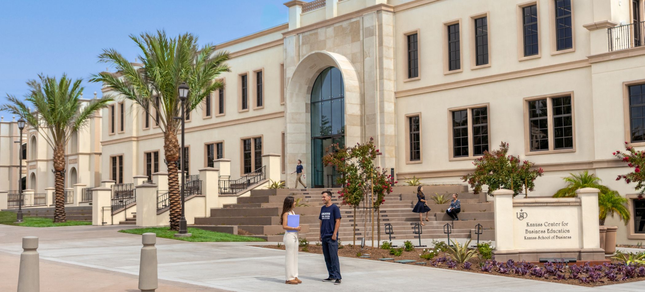 the front of the knauss school of business with students about