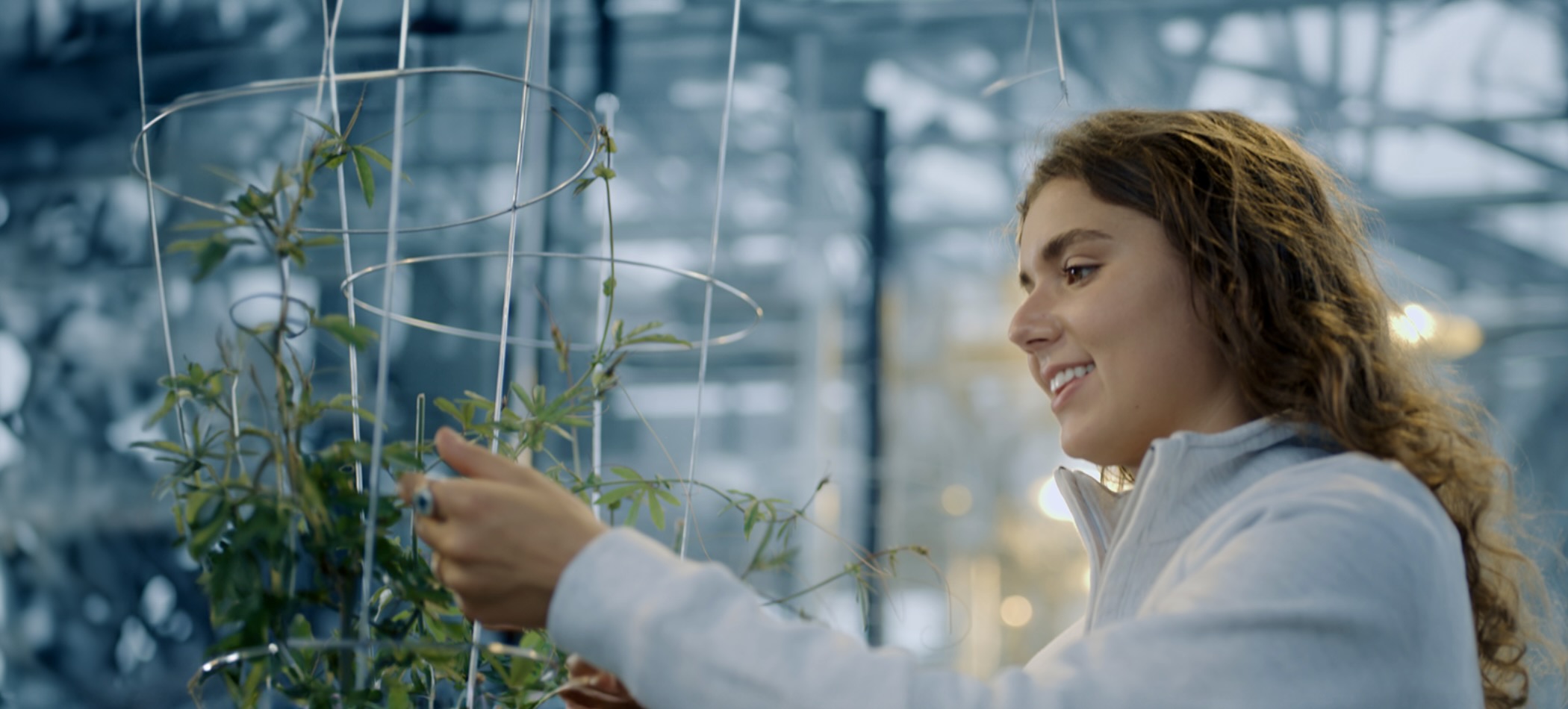 student looking at plants growing in futuristic setting