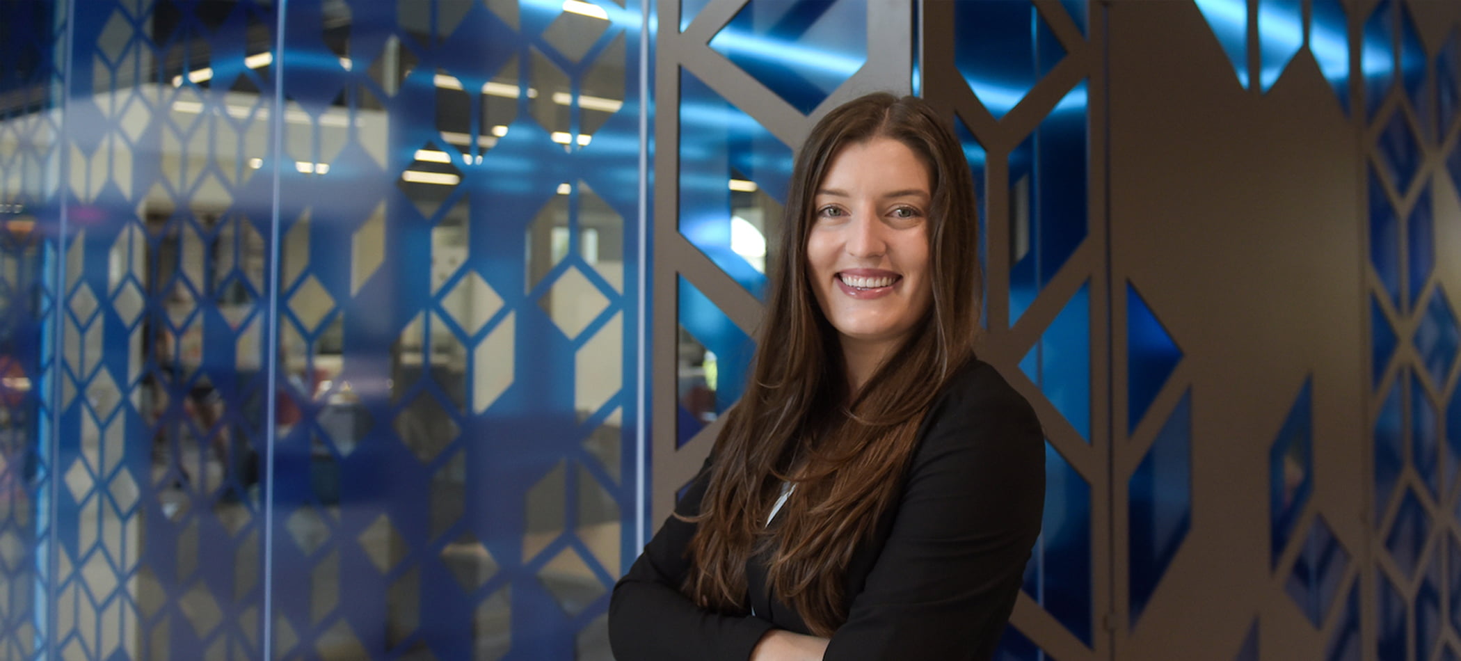 Kemi Kantor JD MSRE smiling in front of the Burnham-Moores Center for Real Estate