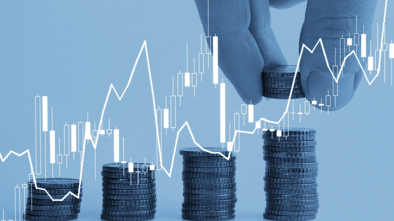 Light blue graphic of a person's finger stacking rows of coins overlaid with bar charts