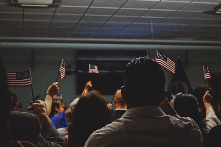 A room full of people holding small American flags
