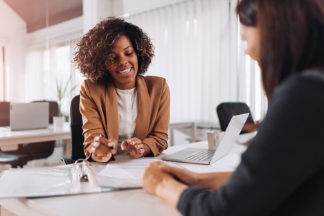 Tax auditor sits at a desk and talks to a client