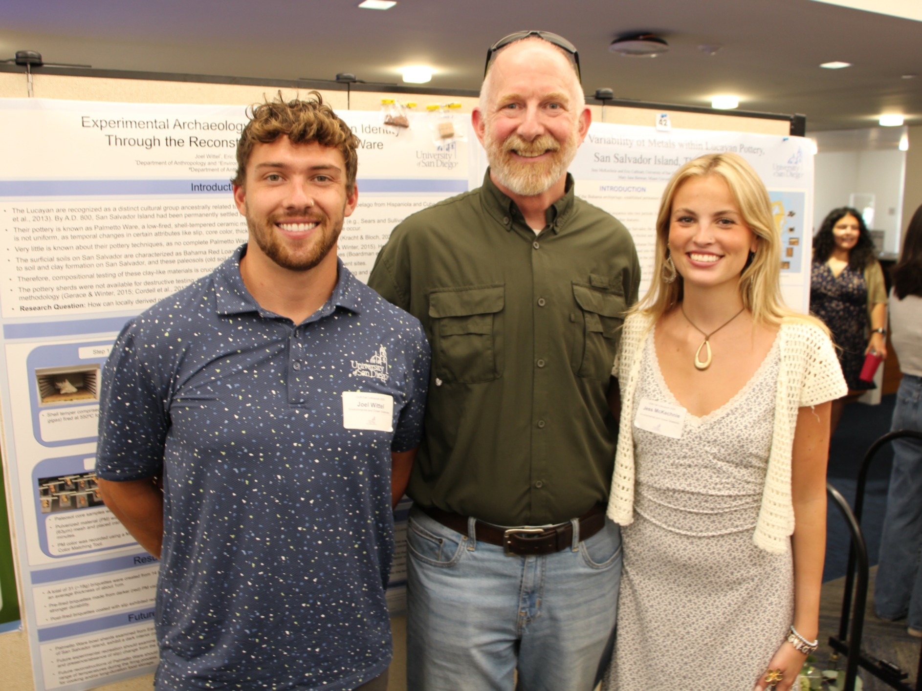 Two students and a professor at a research showcase