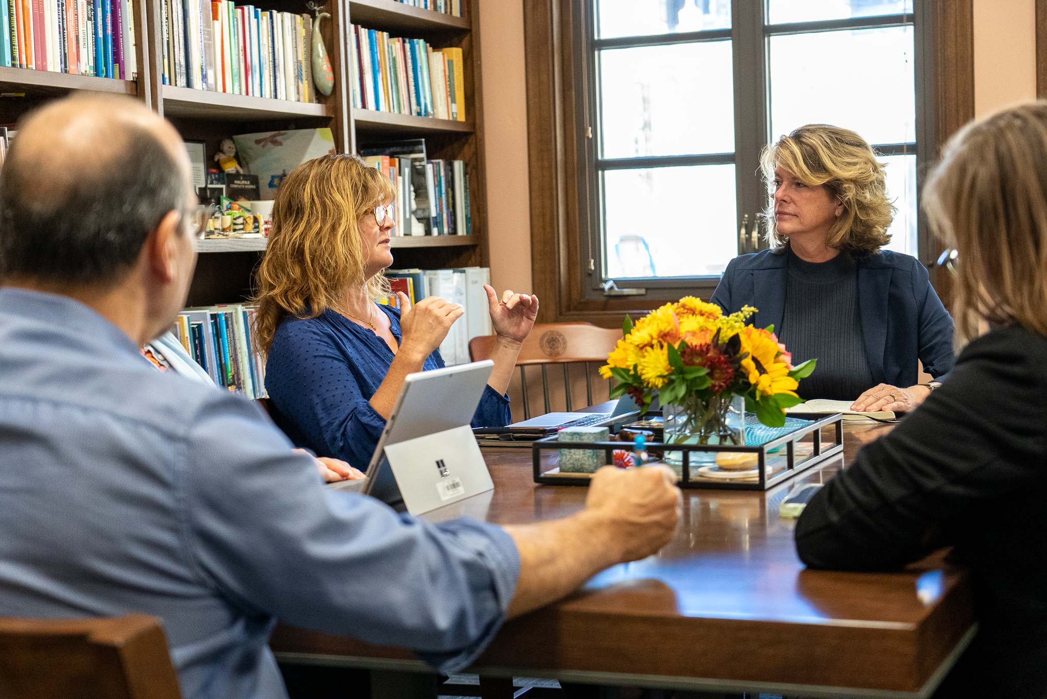 Associate Dean of Faculty Kristin Moran speaking talking with the dean and other faculty.