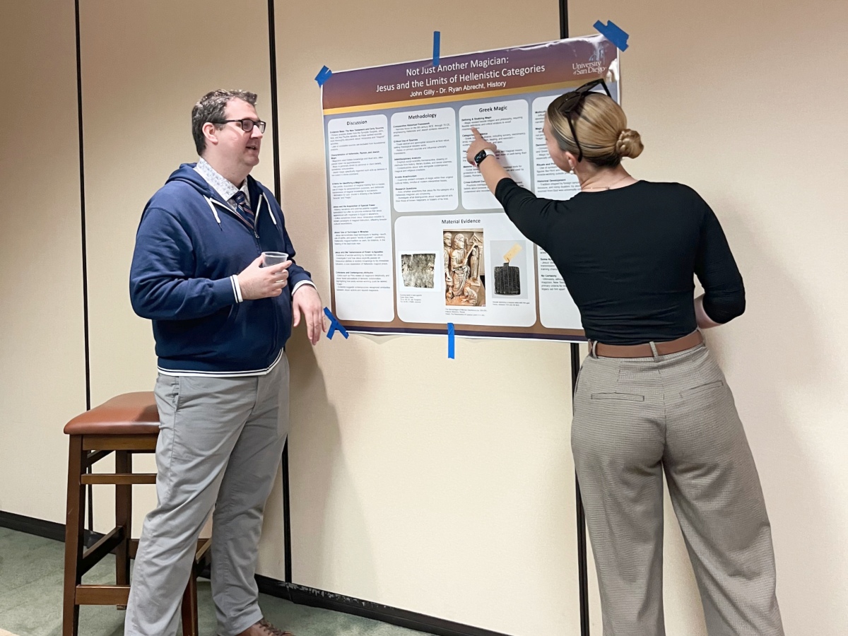 Two students standing in front of a research poster.
