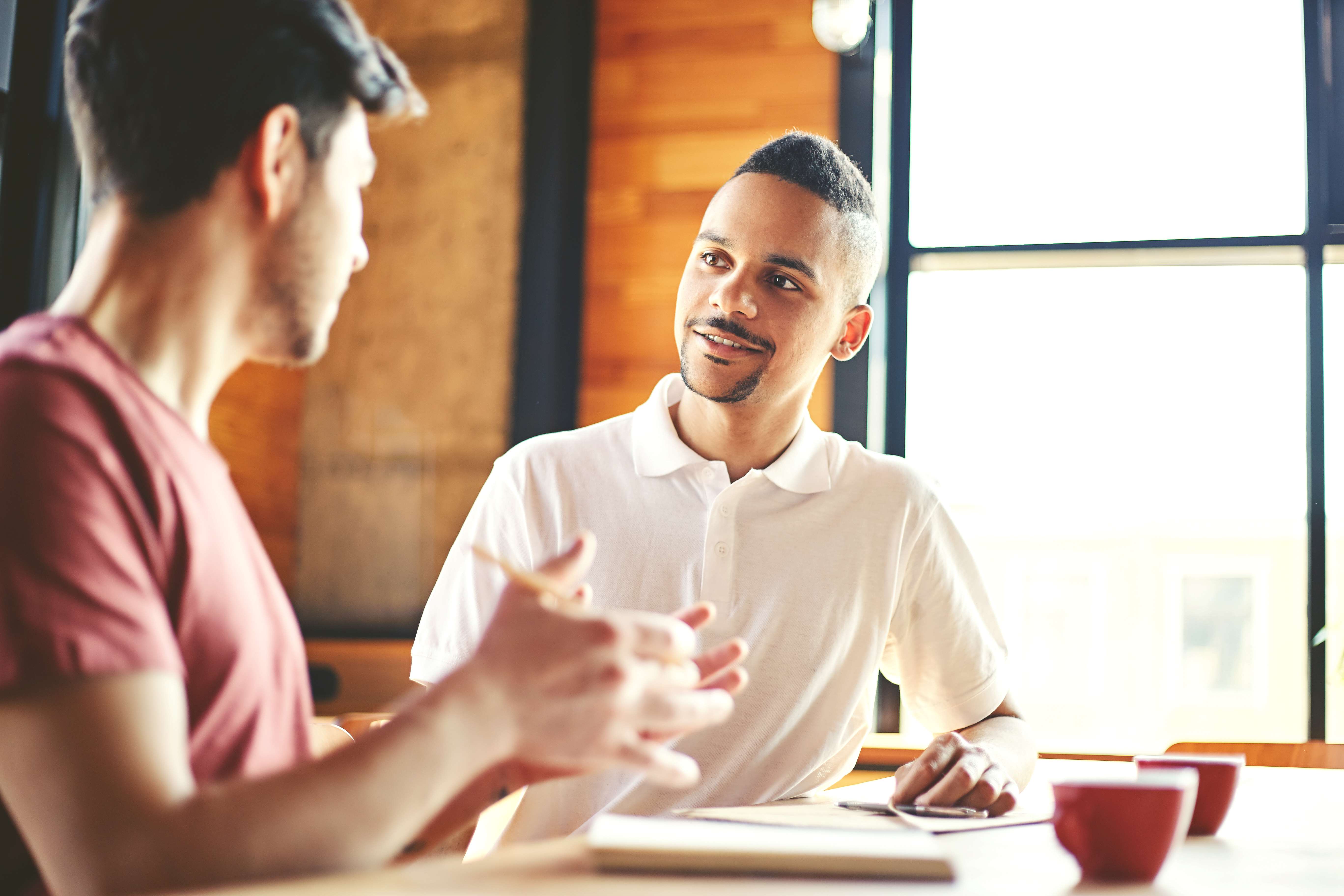 two college students talking at desk
