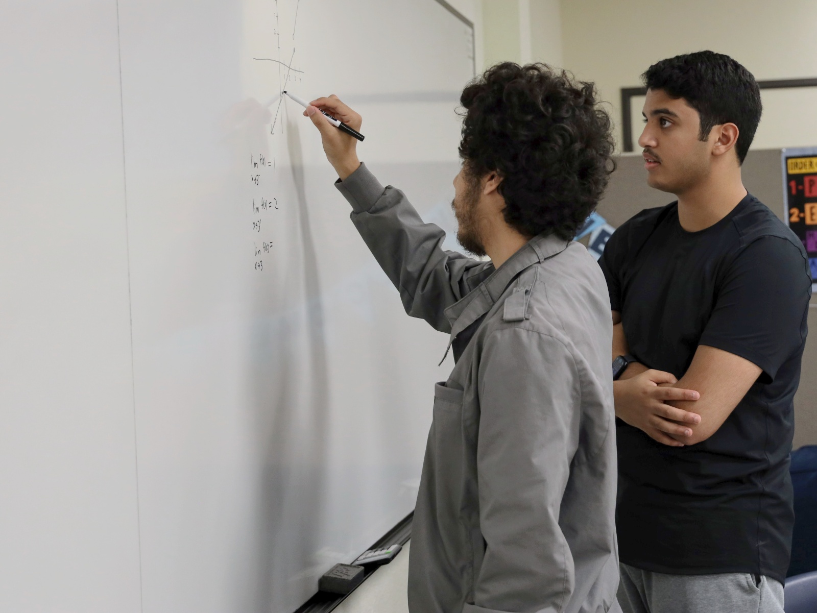 A peer tutor helping another student with math.