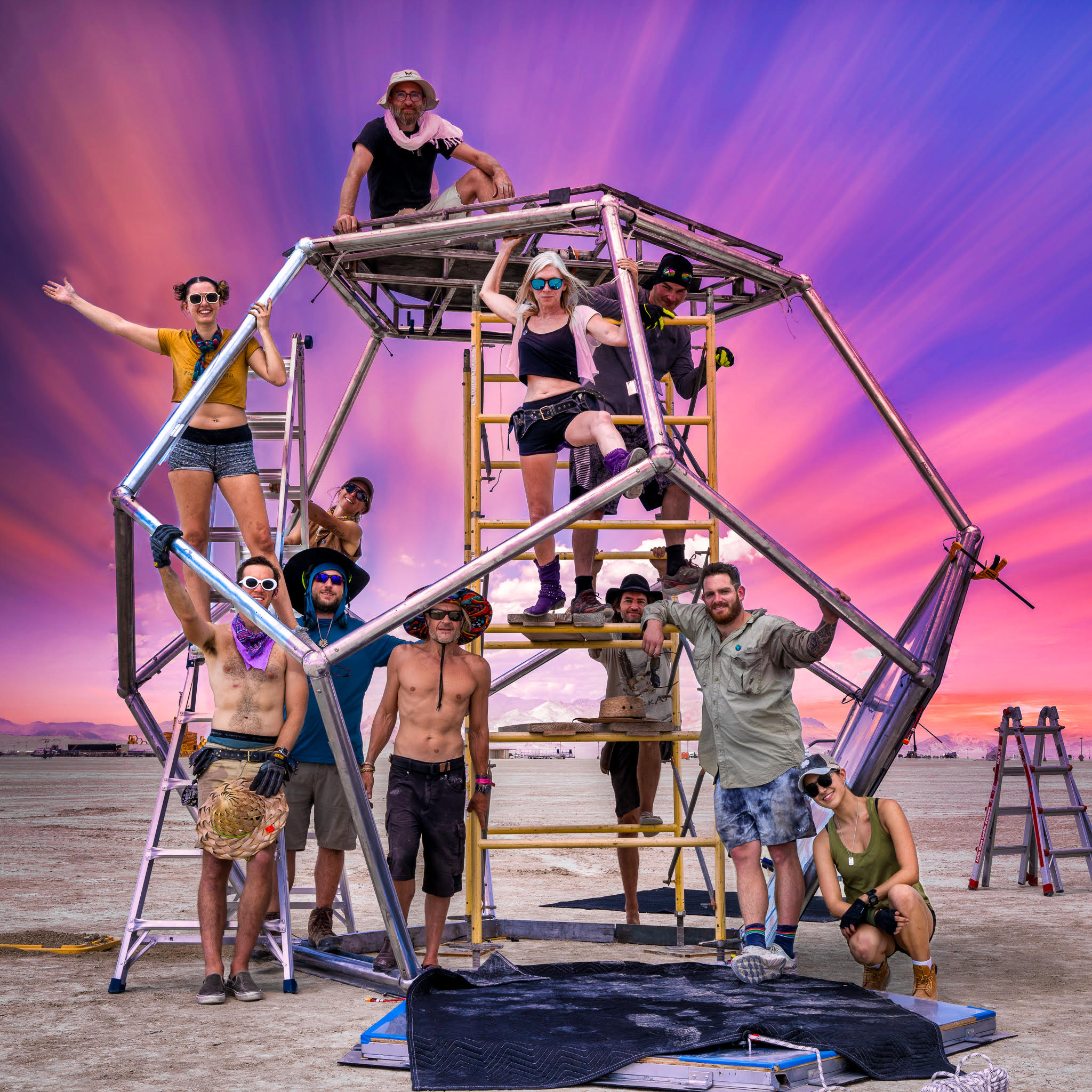 The ArtBuilds team posing on top of their sculpture, Unfolding Humanity.