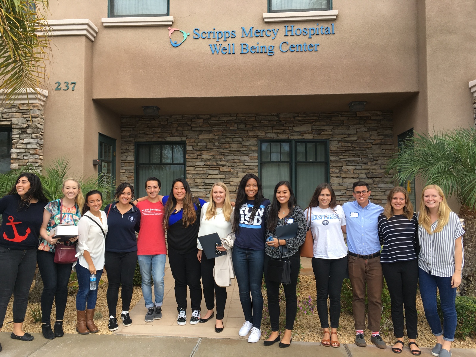 A group of USD students standing in front of the Scripps Mercy Hospital Well Being Center.