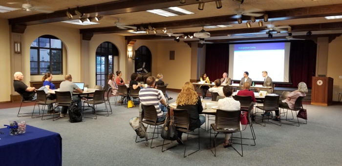 CEE event in Salomon Hall with rounds of tables and a panel.