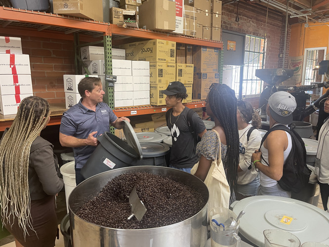 people talking around a coffee roaster