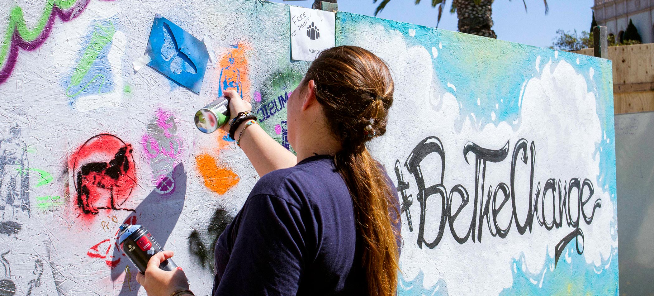 A USD student writing on a wall
