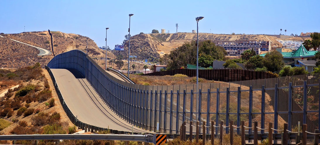 U.S. Mexico border wall dividing a street