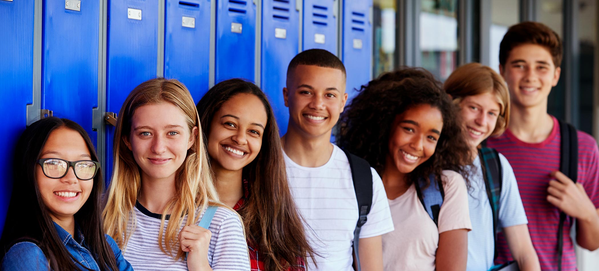 A group of high school students standing in front of a locker