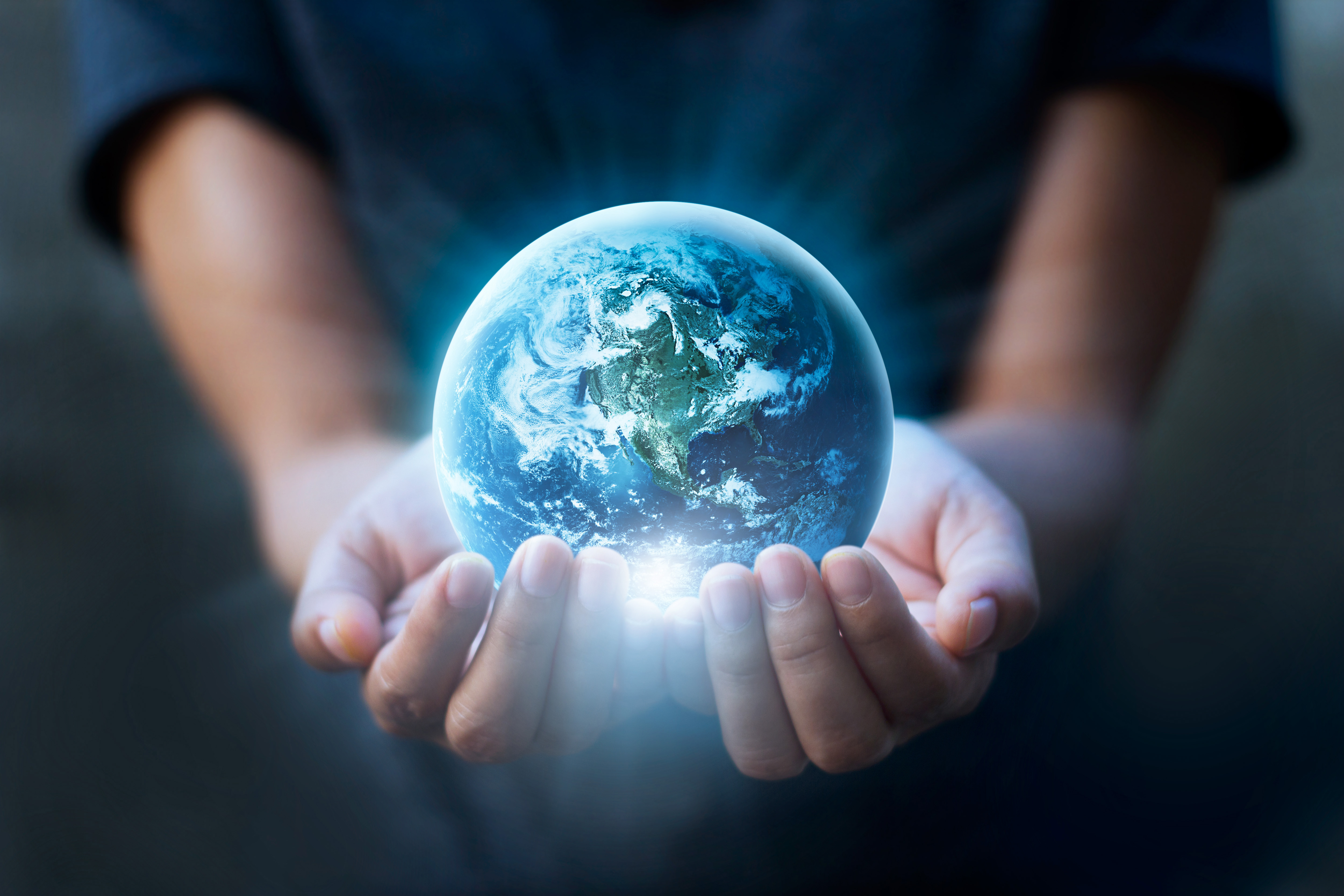 hands holding small version of planet earth