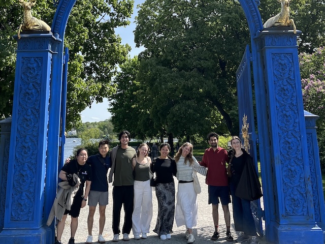 group of students under blue arch