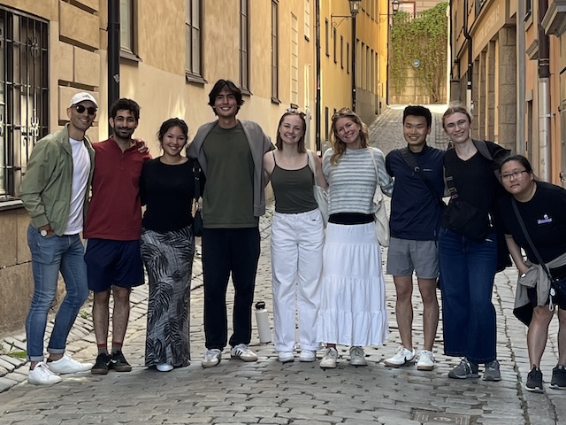 students with faculty on cobblestone street