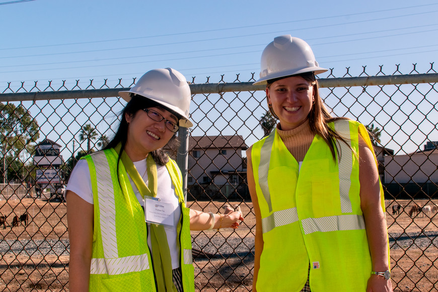 two women in hard hats and yellow vests