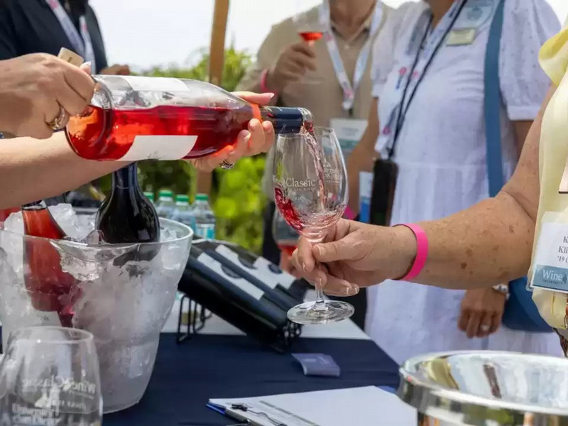 photo of a vendor pouring a glass of wine for an attendee