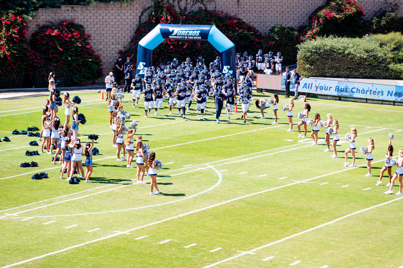 USD football players running onto the field