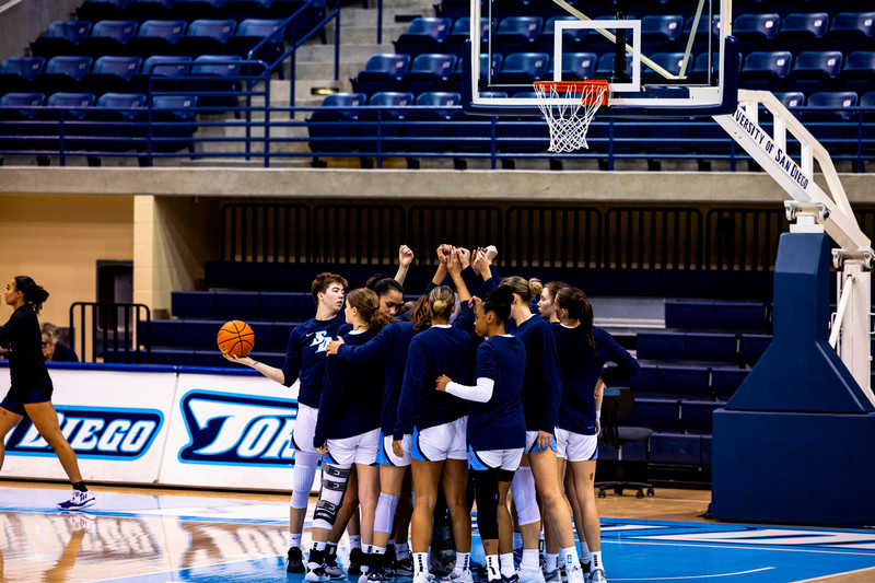 USD women's basketball team in a huddle