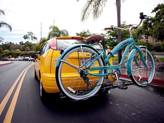 A car with a bicycle on campus