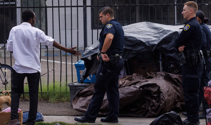 San Diego police officers enforcing the recently passed unsafe camping ordinance in San Diego. Photograph: Mike Blake/Reuters