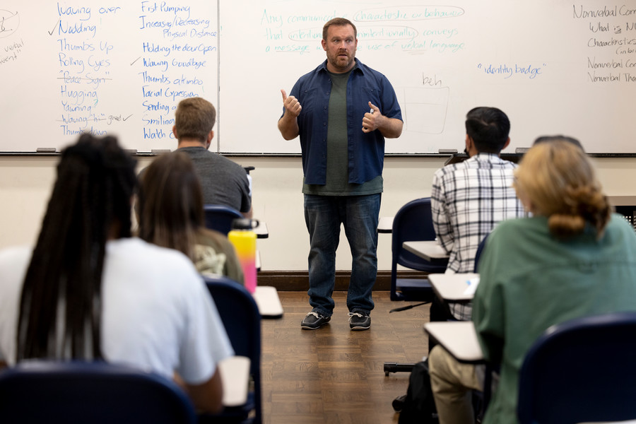 Professor Jonathan Bowman standing at front of class during instruction.
