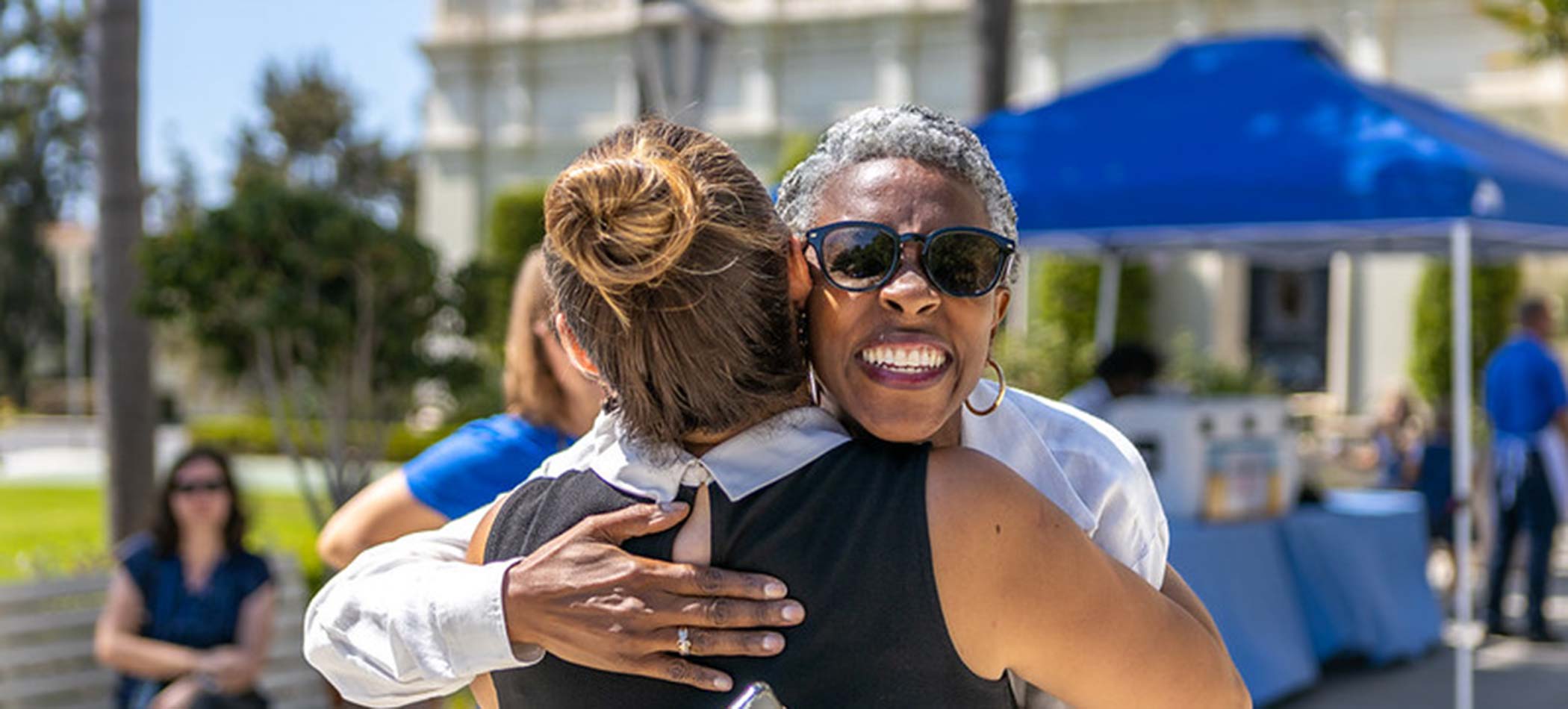 USD employees hugging on campus