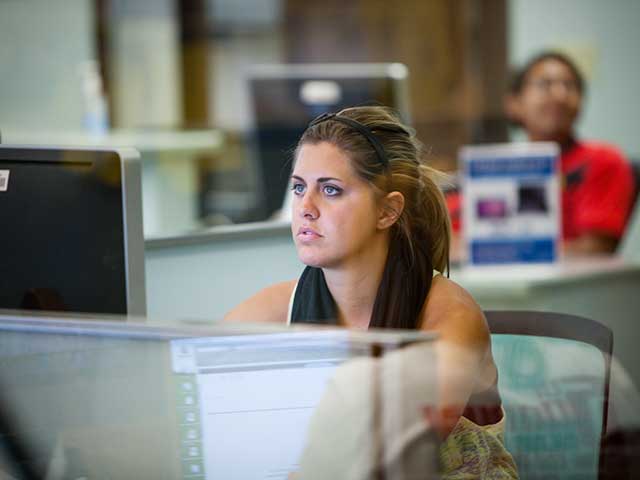 A student working on a computer in the computer labs