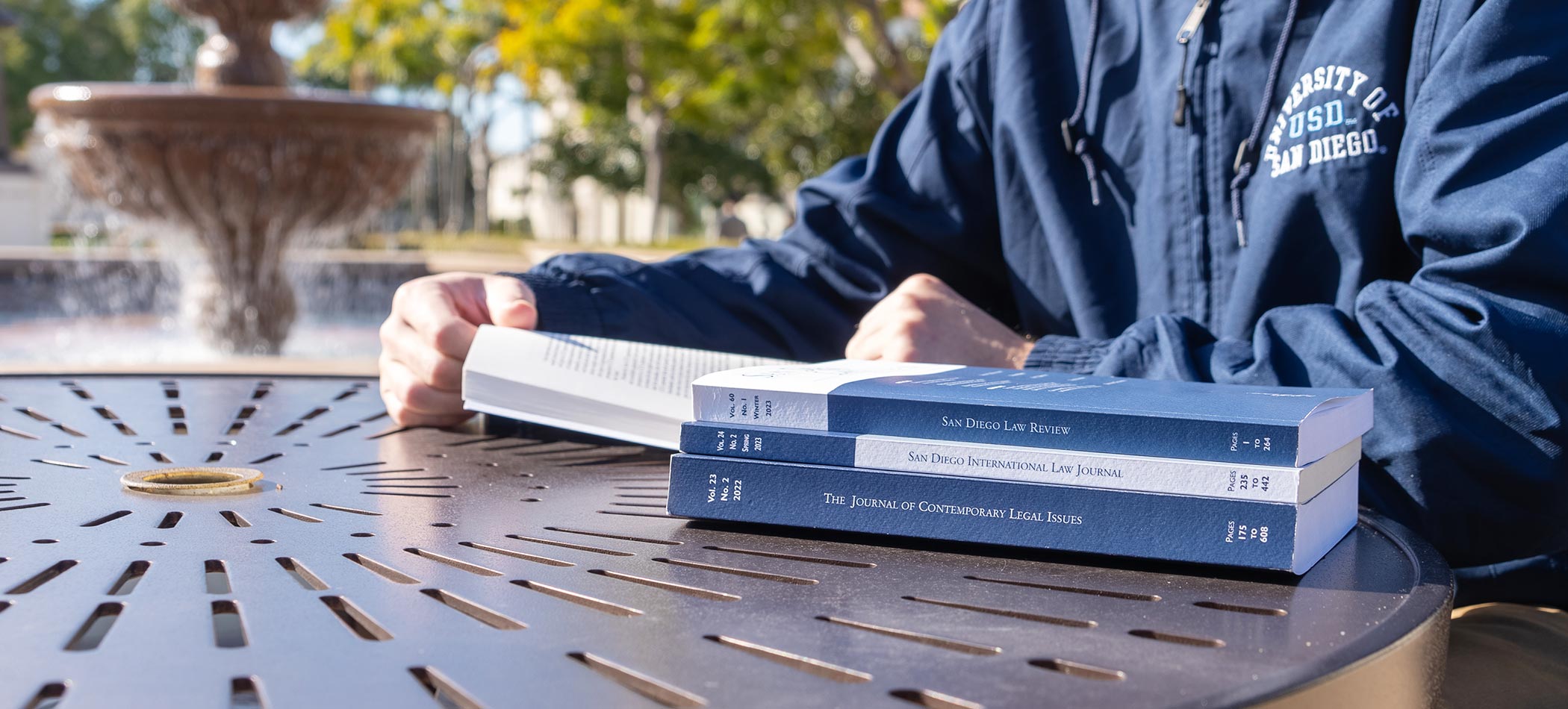 A stack of journals on a table by the USD fountain