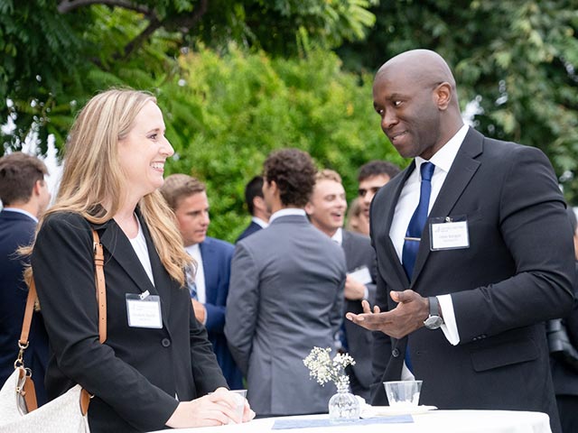 two students in suits talking at a table