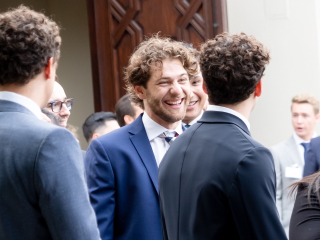 student in a suit laughing