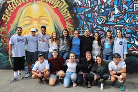 students standing in front of colorful mural