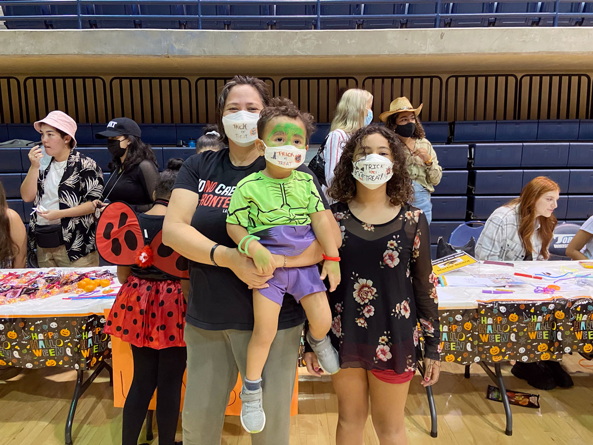 Parents and children in front of Mortar Board station at Halloween Hoopla