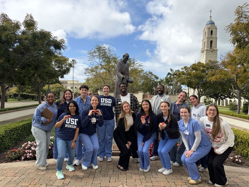 group of nursing students in center of USD campus with immaculata in background