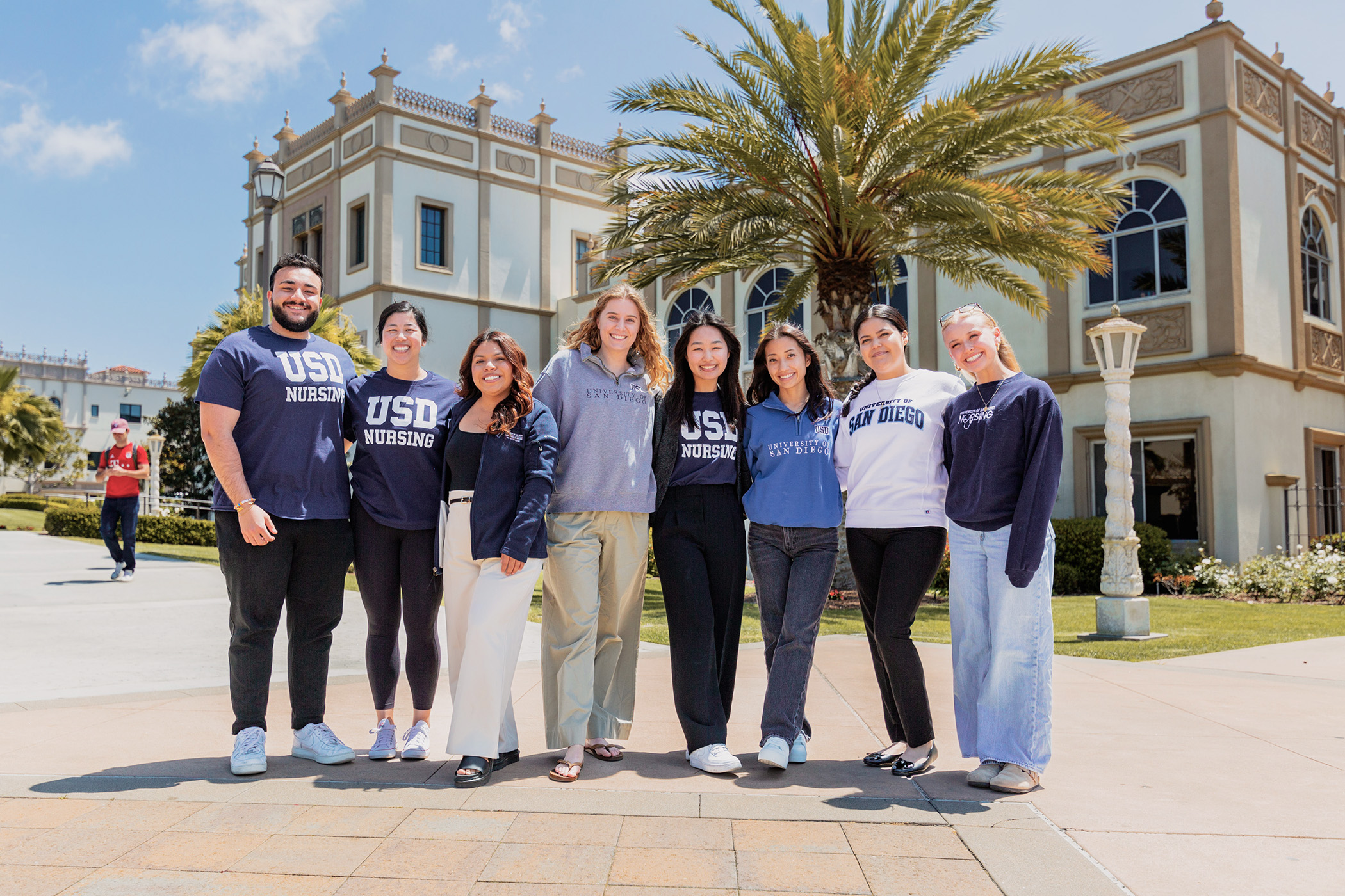 Group of students wearing torero wear in front of school of nursing