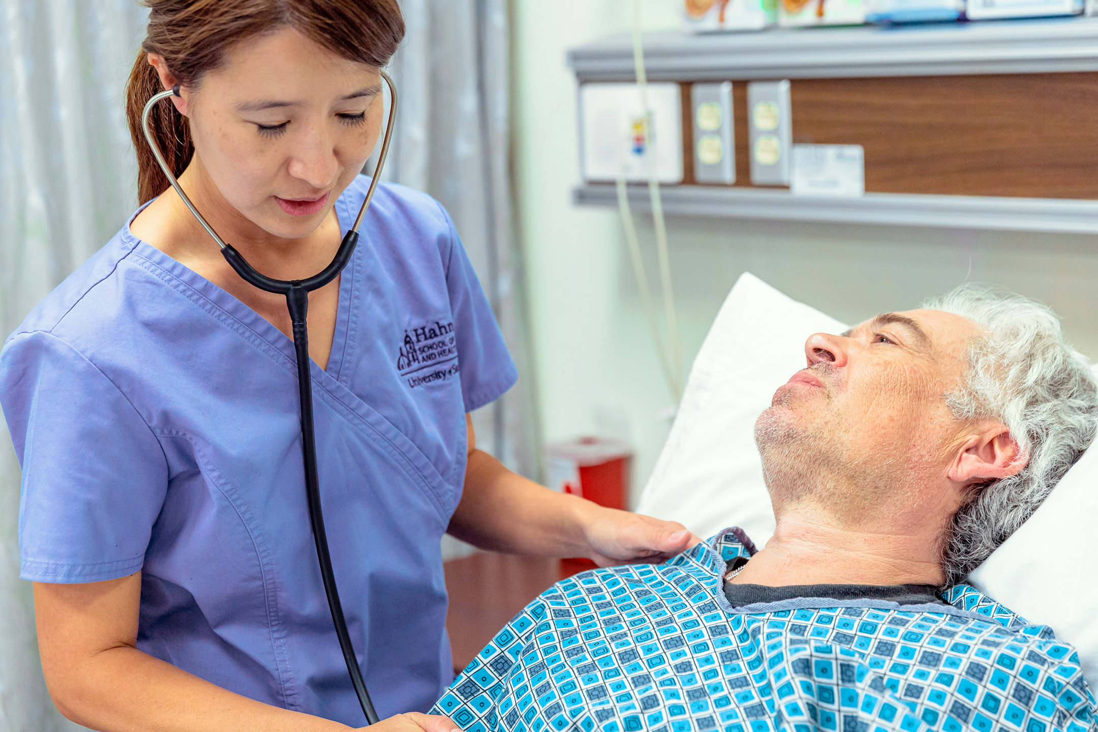 nurse checking patient at bedside