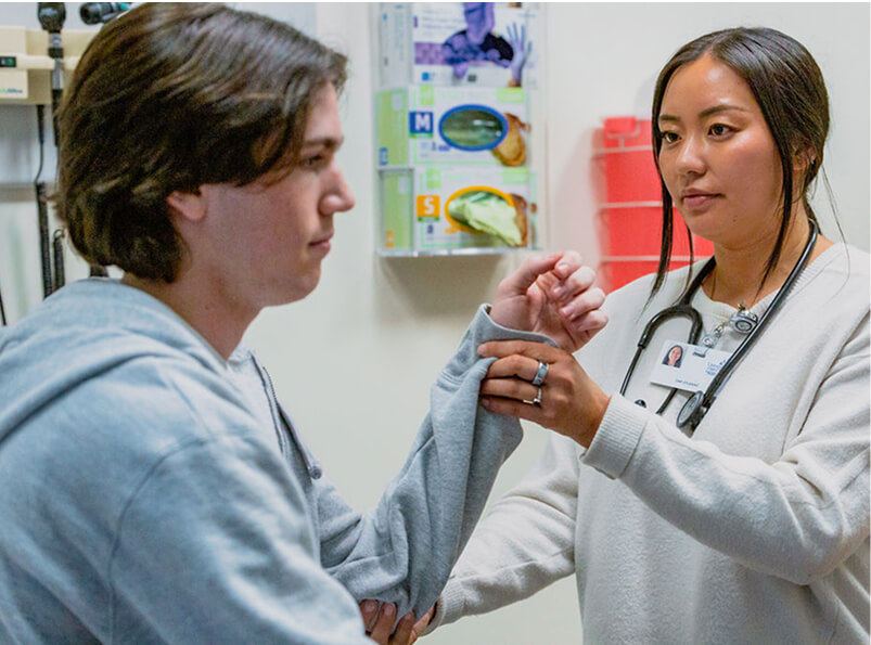 Student examining patients wrist