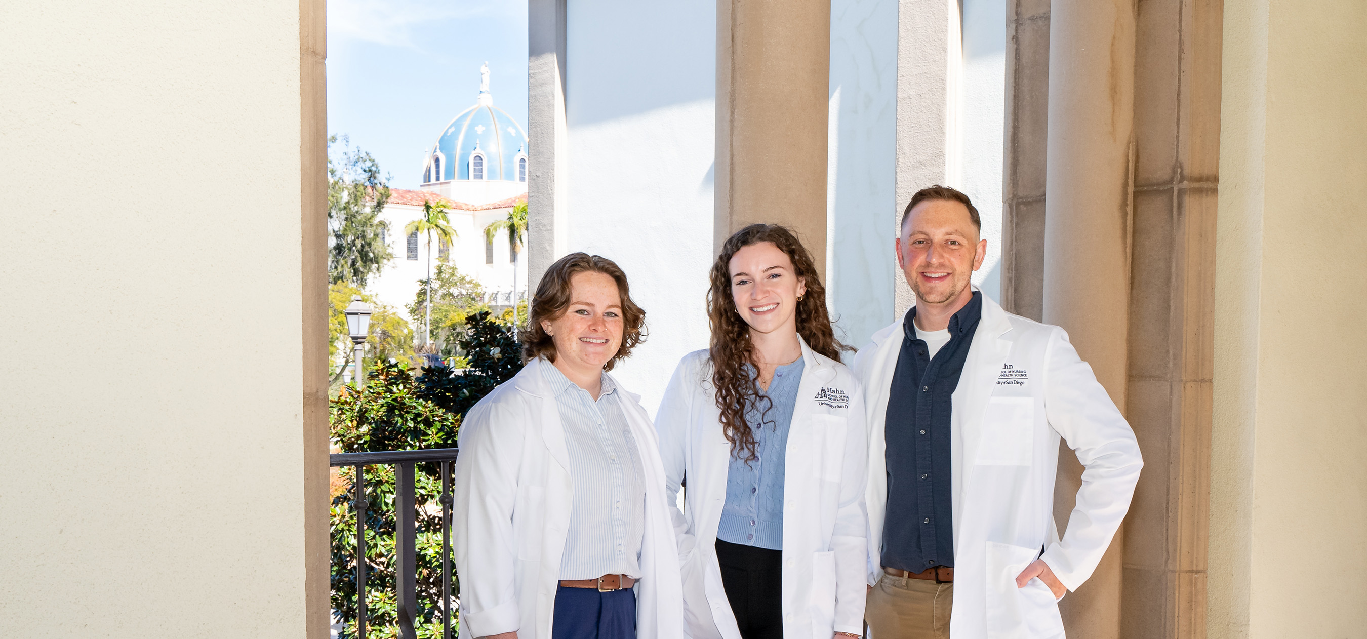 Three DNP nursing students standing in breezeway with immaculata in the background