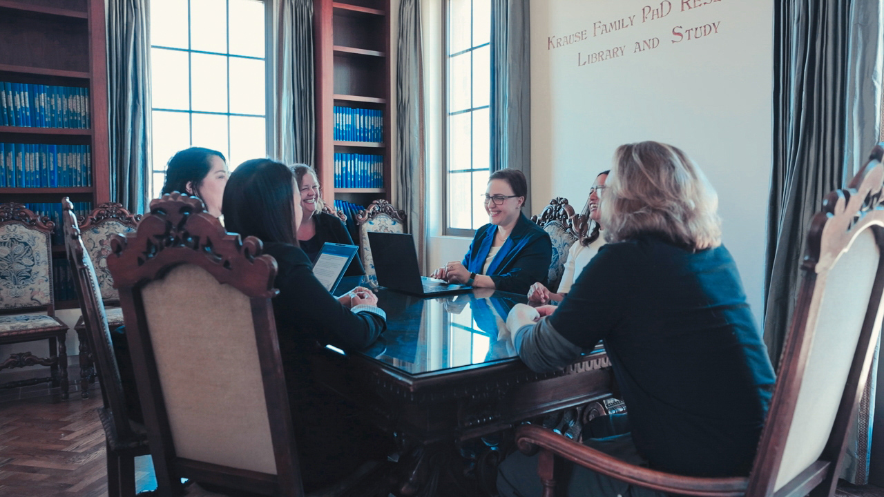 PhD students in library discussing topics in nursing
