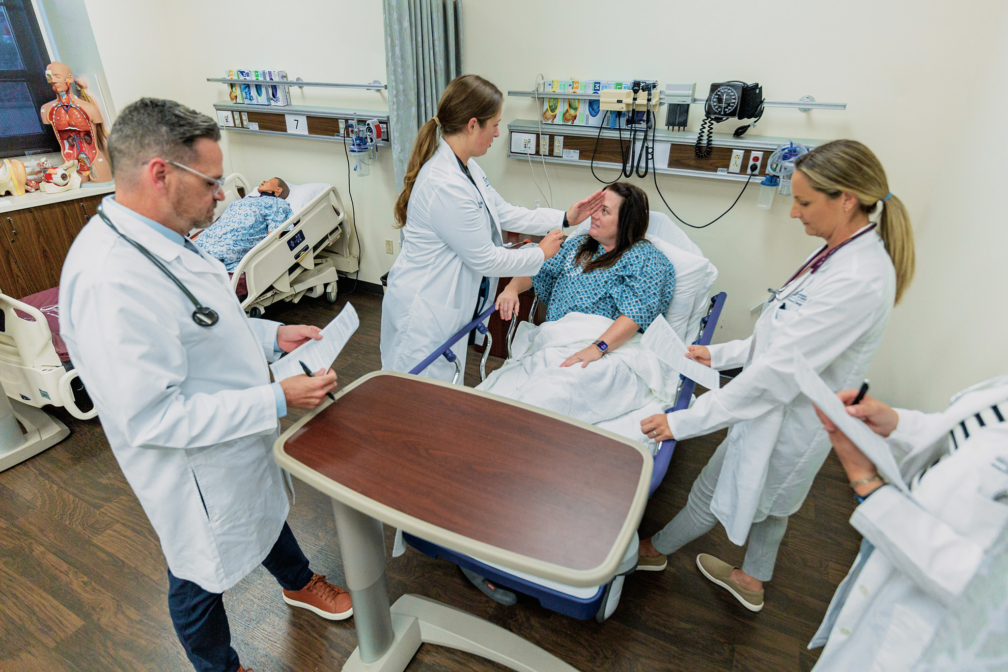 CNS students in sim lab during a stroke code with standardized patient