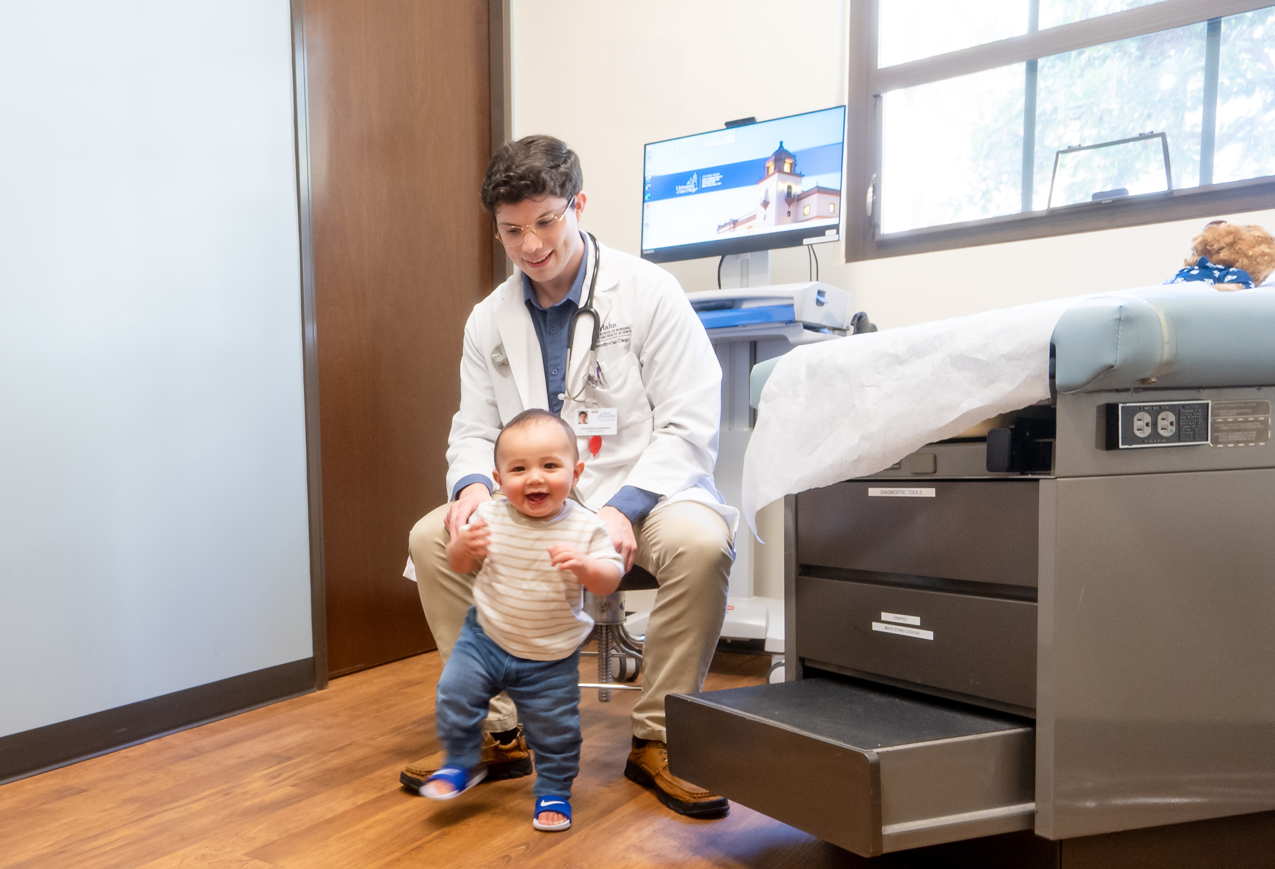 baby walking while observed by pediatric nurse practitioner student